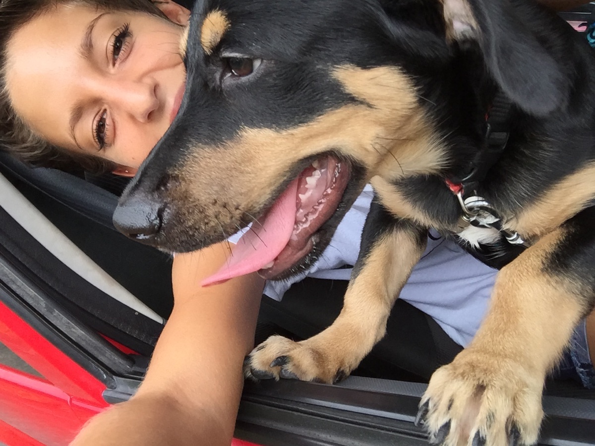 Luisa sourit avec son chien contre elle